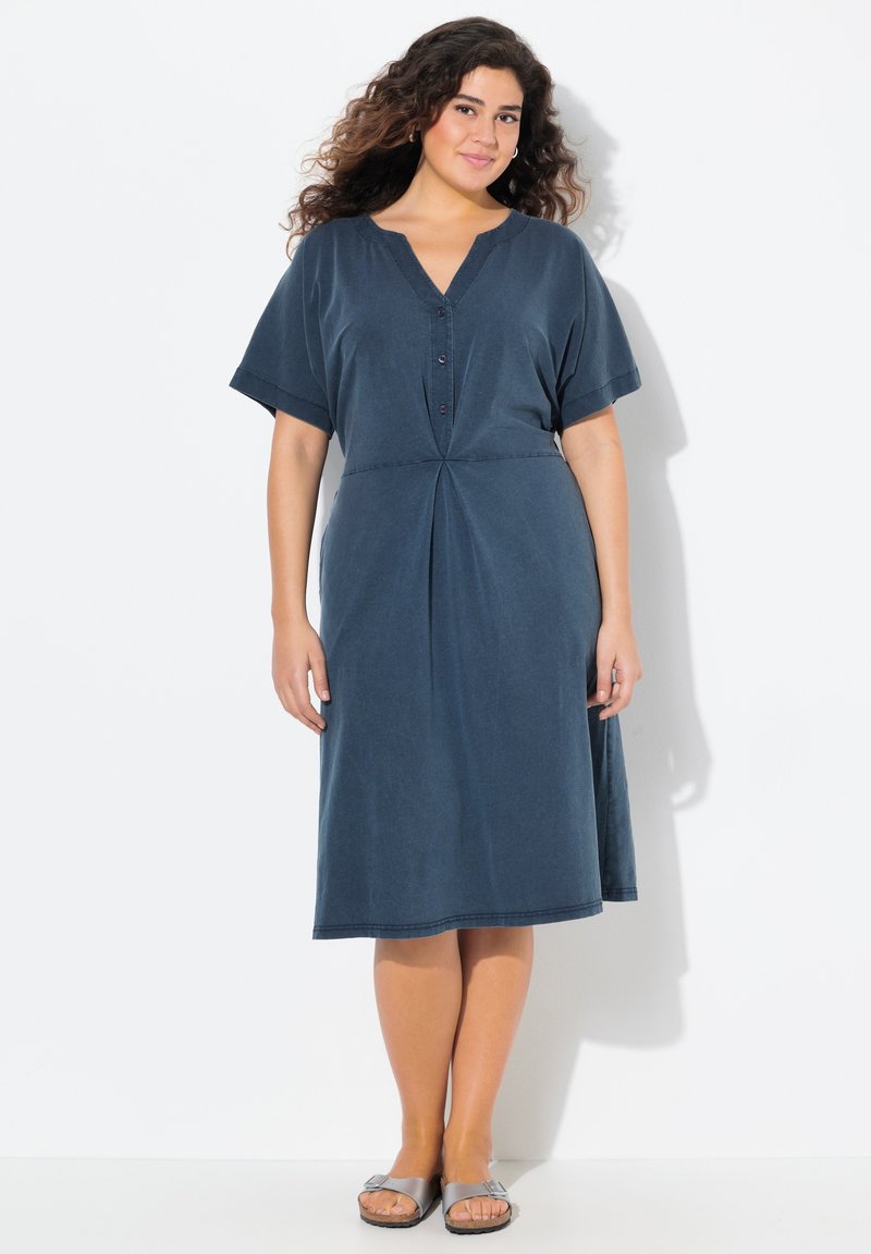 Tummansininen mekko, jossa on lyhyet hihat, V-pääntie, napitettu etuosa ja A-linjainen muoto; valmistettu pehmeästä kankaasta, jossa on hieno kiilto.