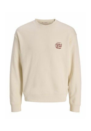 Cream-colored crewneck sweatshirt with long sleeves and small red text logo on left chest reading "Studio 90."
