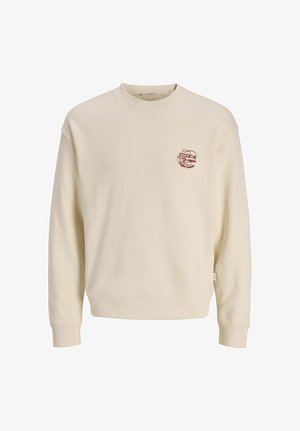 Cream-colored crewneck sweatshirt with long sleeves and small red text logo on left chest reading "Studio 90."