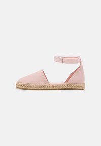 Roze canvas espadrille met een enkelbandje, jute zool en een afgeronde tekening. Beschikt over een gestructureerde stof en minimale stikdetails.