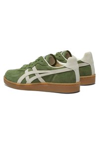 Zelené semišové tenisky s bílými detaily, s nízkým designem, kulatou špičkou a gumovou podrážkou. Obsahují perforované detaily pro prodyšnost.