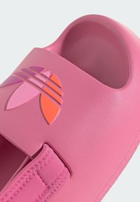 Rosa Rutschsandale aus strukturiertem Synthetikmaterial, verstellbarem Riemen und einem bunten Logo mit lila und orangefarbenen Akzenten. Flache Sohle.