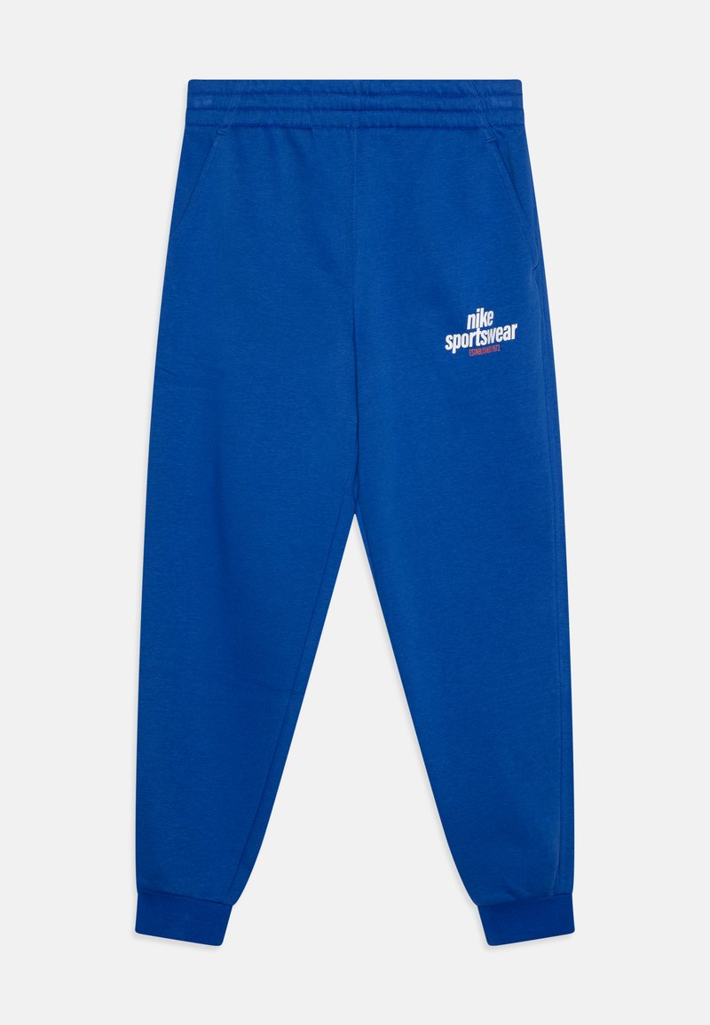 Modre trenerke iz mehkega materiala z elastičnim pasom, stranskimi žepi in belim logotipom Nike Sportswear na stegnu.