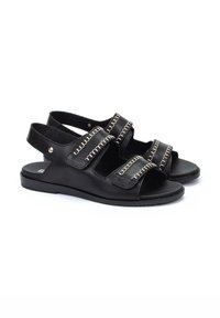 Sandalias de cuero negro con dos correas anchas que presentan costuras en contraste, punteras abiertas y correas traseras para un ajuste seguro. Suela plana.