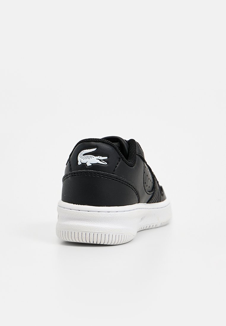 Zwarte lederen sneaker met een witte rubberen zool, met perforaties aan de zijkanten en een wit krokodillenlogo op de hiel.