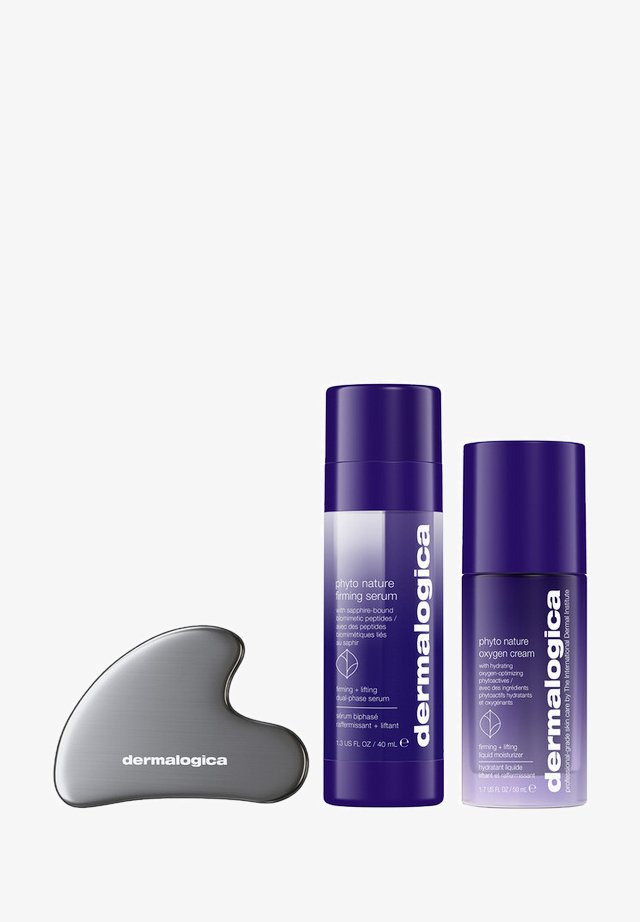 Ensemble de soins Dermalogica comprenant deux bouteilles violettes étiquetées « sérum raffermissant phyto nature » et « crème oxygène phyto nature », ainsi qu'un outil de massage argenté.