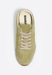 Zielona oliwkowa zamszowa sneaker z teksturowanym kremowym obcasem, beżowymi sznurówkami oraz logo na języku. Brązowa gumowa podeszwa.