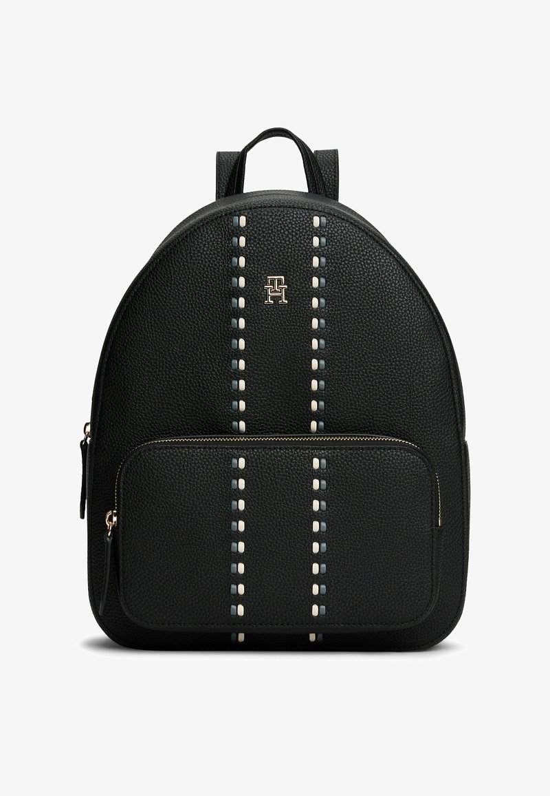 Mochila de cuero negro con forma redondeada, superficie texturizada, costuras decorativas en blanco y gris, herrajes dorados y un bolsillo frontal con cremallera.