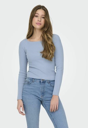 Lichtblauw geribbeld langwerpig shirt met een vierkante halslijn, strakke pasvorm en textuurstof, gedragen met lichtblauwe high-waisted jeans.