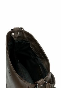 Donkerbruine leren tas met zichtbare zwarte stoffen binnenvoering, voorzien van een interne ritsvak en metalen ringdetail op de schouderband.