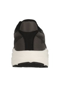 Zapatilla atlética en negro y gris con parte superior de malla, acentos texturizados y mediopié blanco. Cuenta con una suela gruesa de goma y un diseño minimalista.