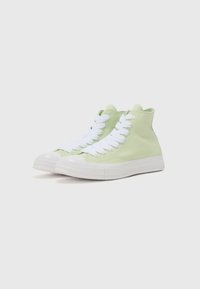 Sneakers de tip high-top din pânză verde deschis, cu șireturi albe și talpă din cauciuc. Au un vârf rotunjit și ochiuri metalice pentru șireturi.