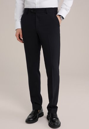 Pantaloni tailored bleumarin cu o textură fină, bucle pentru curea și închidere cu un buton. Asortați cu mocasini negri pentru un look formal.