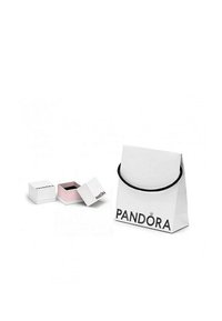 Bela papirnata torba za nakupovanje s črnim ročajem in logotipom "PANDORA", v zgornjem delu pa je manjša bela in roza škatlica za nakit, ki je rahlo odprta.
