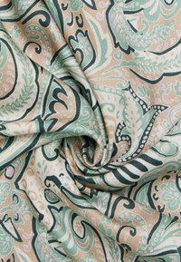 Bomuldsstof med indviklet paisley-mønster i grøn, beige og sort. Glat tekstur med blomstermotiver og svulstige design.