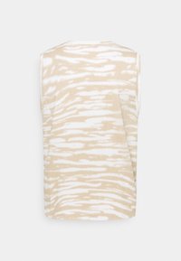 Top sin mangas con un patrón ondulado en beige y blanco. Tejido suave con un ajuste relajado. Escote redondo y sin herrajes visibles.