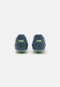Scarpini da calcio blu con logo "KING" giallo sul tallone, cima testurizzata e dettagli verdi sulla suola. Progettati per prestazioni sull'erba.