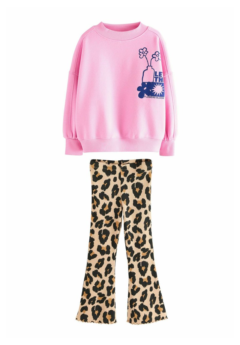 Rosa sweatshirt med puffärmar som har en blå blommig grafik, parat med vida leopardmönstrade byxor i beige och svart.
