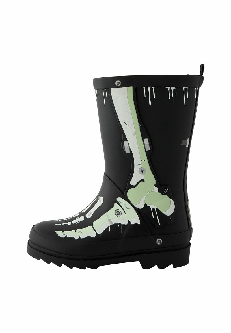 Botte en caoutchouc noire avec des os verts et blancs de style radiographie imprimés le long du côté et des détails de gouttes de peinture blanche sur le bord supérieur.
