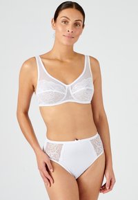 Soutien-gorge en dentelle blanche avec un panneau transparent et des bretelles réglables, associé à une culotte blanche taille haute ornée de détails en dentelle sur les côtés et d'un nœud.
