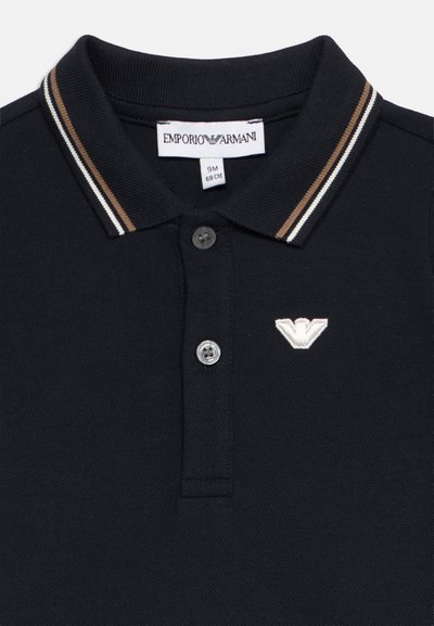 Polo nera con colletto a righe marroni e bianche, due bottoni, logo Emporio Armani sul petto e etichetta con taglia 9 mesi 68 cm.