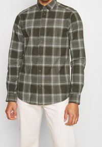 Grün-weiß kariertes Hemd mit Knopfkragen, gefertigt aus strukturiertem Stoff, mit langen Ärmeln und braunen Knöpfen.