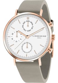 Rund klocka med en vit urtavla, roséguldaccent och ett grått silikonarmband. Inkluderar subur för dag och datum, smala timmarkörer och visare.