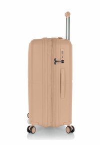 Hartschalenkoffer in hellpfirsichfarbener Ausführung, ausgestattet mit einem Doppelreißverschluss, seitlichem Griff, integriertem Schloss und vier multidirektionalen Rollen.