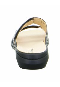 Black sandal with an open back and toe. Features two textured straps and a cushioned insole. Rounded heel and smooth, minimalist design.