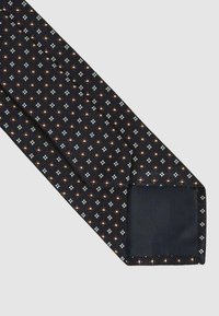 Cravat bleumarin cu un model geometric, având accente albe și maronii. Material texturat cu un finisaj neted la vârf.