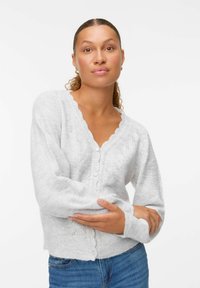 Cardigan en tricot gris avec un col en V festonné, fermeture par boutons à l'avant et motifs décoratifs. Texture douce et manches ajustées.