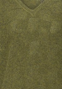 Gros plan sur un tissu tricoté vert avec des motifs géométriques subtils et un décolleté en V.