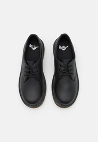 Scarpe in pelle nera con punta arrotondata, cuciture leggere e design con lacci. Presentano una soletta testurizzata e una suola piatta in gomma.