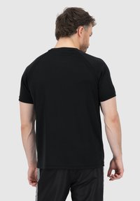 Schwarzes T-Shirt mit kurzen Ärmeln, glatter Textur und Raglanärmeln. Verfügt über ein einfaches Design ohne sichtbare Logos oder Muster.