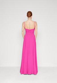 Robe longue rose avec des fines bretelles, un corsage ajusté avec des fronces et une jupe fluide. Tissu lisse avec un éclat subtil.