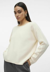 Pull crème à coupe décontractée, col rond et manches longues. Texture douce avec des bords c�ôtes aux poignets et à l'ourlet. Assorti à un pantalon sombre et ajusté.