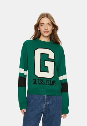 Maglione verde lavorato a maglia con un grande logo bianco "G", strisce bianche e nere sulle maniche e polsini e orlo a coste.