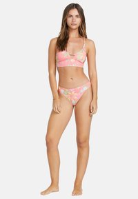 Rúžový bikiny set s kvetinovými vzormi. Bralette má dizajn v tvare kľúčovej dierky a tenké ramienka; zodpovedajúce vysoké bikiny spodky.