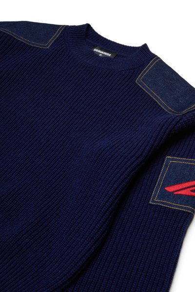 Pull en tricot côtelé marine avec accents en denim sur les épaules et badge logo rouge. Il présente un col ras du cou et un tissu texturé.
