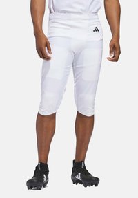 Valkoiset urheilulliset pehmustetut shortsit, joilla on sileä pinta ja joustava vyötärö. Korostettuna mustalla Adidas-logolla ja mustilla jalkapallokengillä.