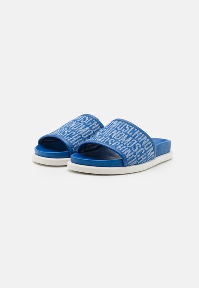 Blå sklisikre sandaler med en teksturert overflate og hvite trykte bokstaver. Hvit gummisåle med en flat, minimalistisk design.