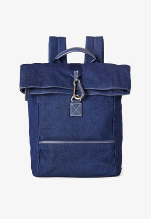 Ciemnoniebieski plecak z dżinsu z górnym uchwytem, klapą na zakładkę, metalowym zatrzaskiem oraz przednią kieszenią na suwak z widocznymi detalami szycia.
