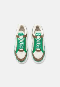 Baskets avec empeigne en mesh beige, accents en suède marron et lacets verts. Semelle blanche avec coutures turquoise. Design moderne et sportif.