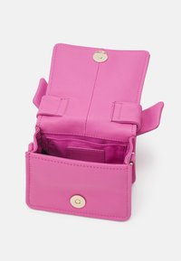 Piccola borsa a tracolla in pelle rosa brillante con il pattino aperto, chiusura magnetica e tasca interna in tessuto.