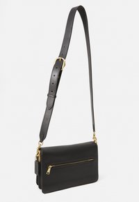 Sacs à bandoulière en cuir noir avec une poche zippée dorée et une bandoulière réglable. Il présente une forme rectangulaire élégante et une texture lisse.