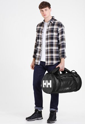 Czarna torba typu duffel z białym logo "HH" i tekstem "<50L>", wykonana z trwałego materiału, w zaokrąglonym kształcie, z podwójnymi uchwytami do noszenia.
