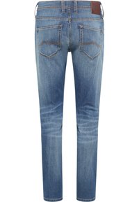 Kék farmernadrág, slim fit szabással, közepes derékvonallal, hátsó zsebekkel ívelt díszvarrással és barna bőr címkével a derékon.