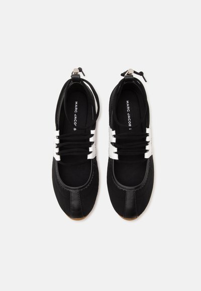 Paire de baskets basses noir et blanc avec lacets et semelles intérieures de marque, vues du dessus sur fond blanc.