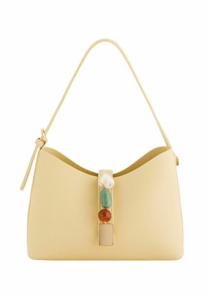 Bolso de cuero beige con una sola correa, decorado con una fila vertical de piedras blancas, verdes y marrones en el cierre frontal.