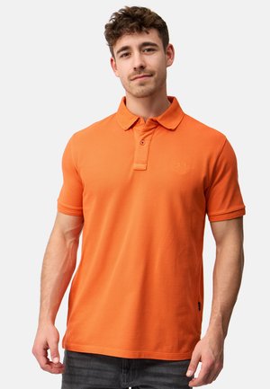 Polo shirt orange avec un col, une patte de boutonnage à deux boutons et des manches courtes. Présente une broderie de logo discrète et un tissu texturé.